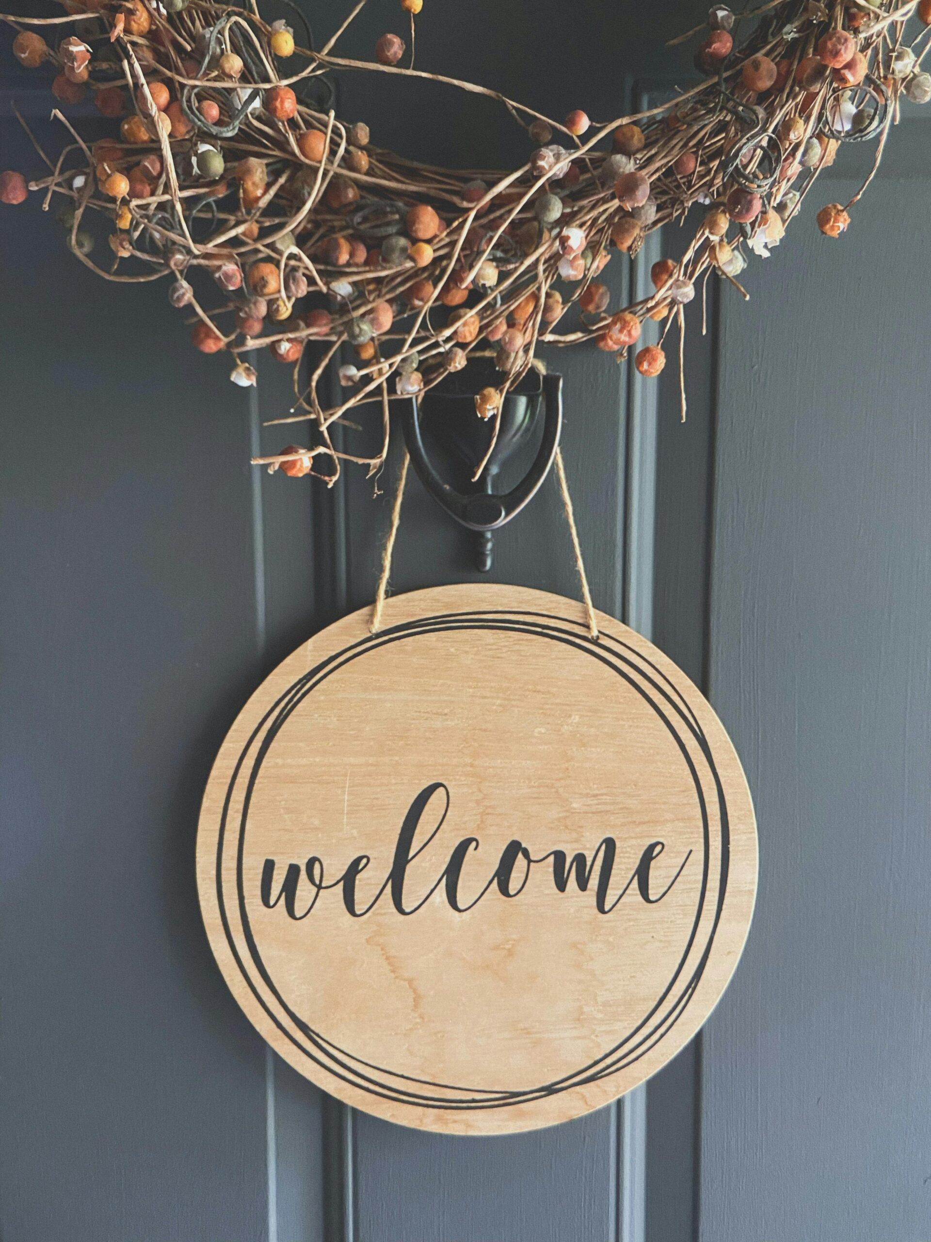 A wooden welcome sign hanging on a front door